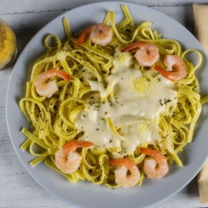 Delicious creamy fettuccine pasta with shrimp, beautifully plated on a rustic wooden table for a gourmet experience.